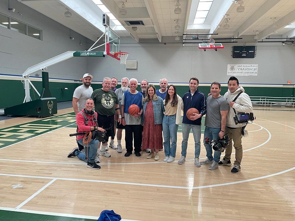 A group of filmmakers standing on a basketball court